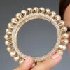 Golden Plated Off White Alloy Stone Pearl Bangles Party Wear